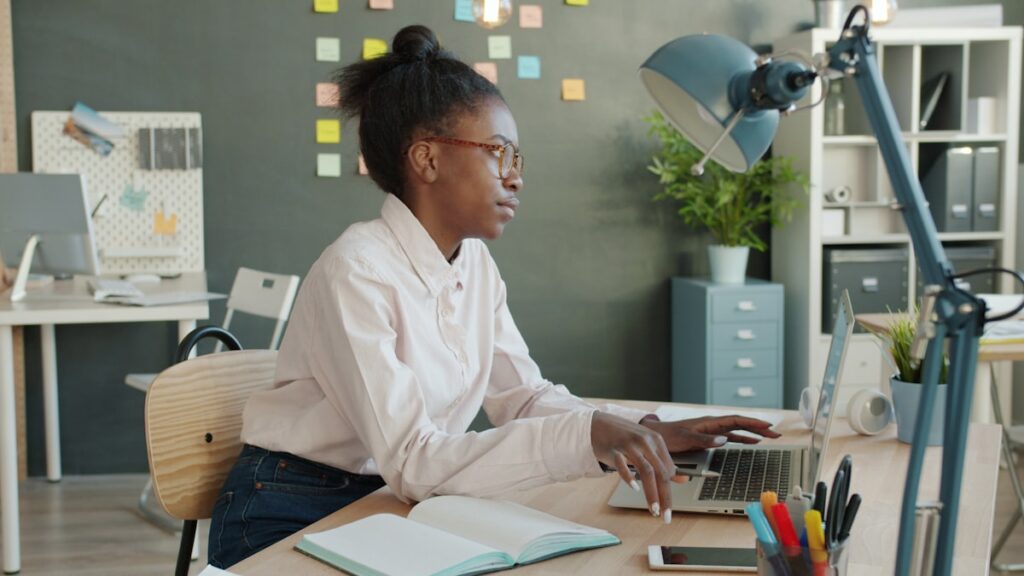 Exhausted woman at desk removing glasses