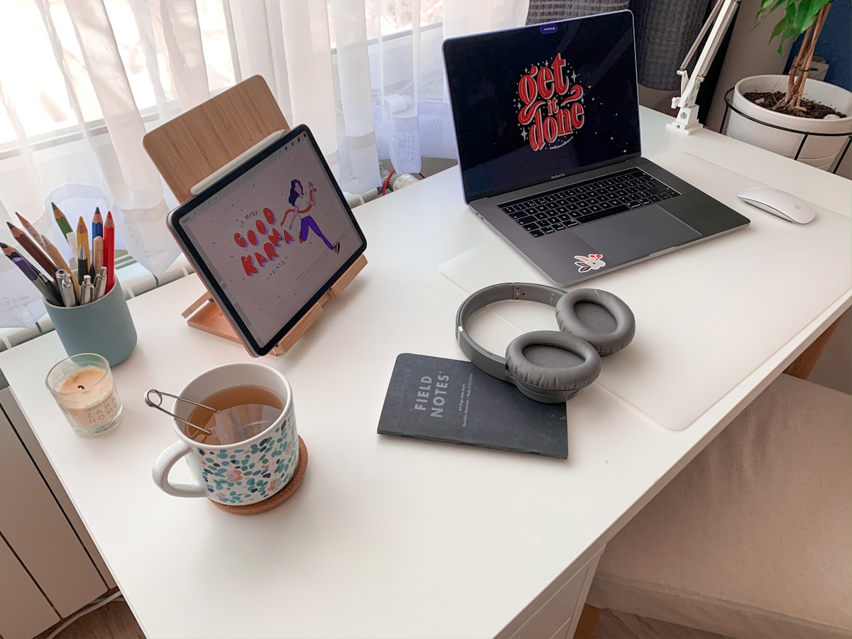 Coffee mug beside laptop computer on white table